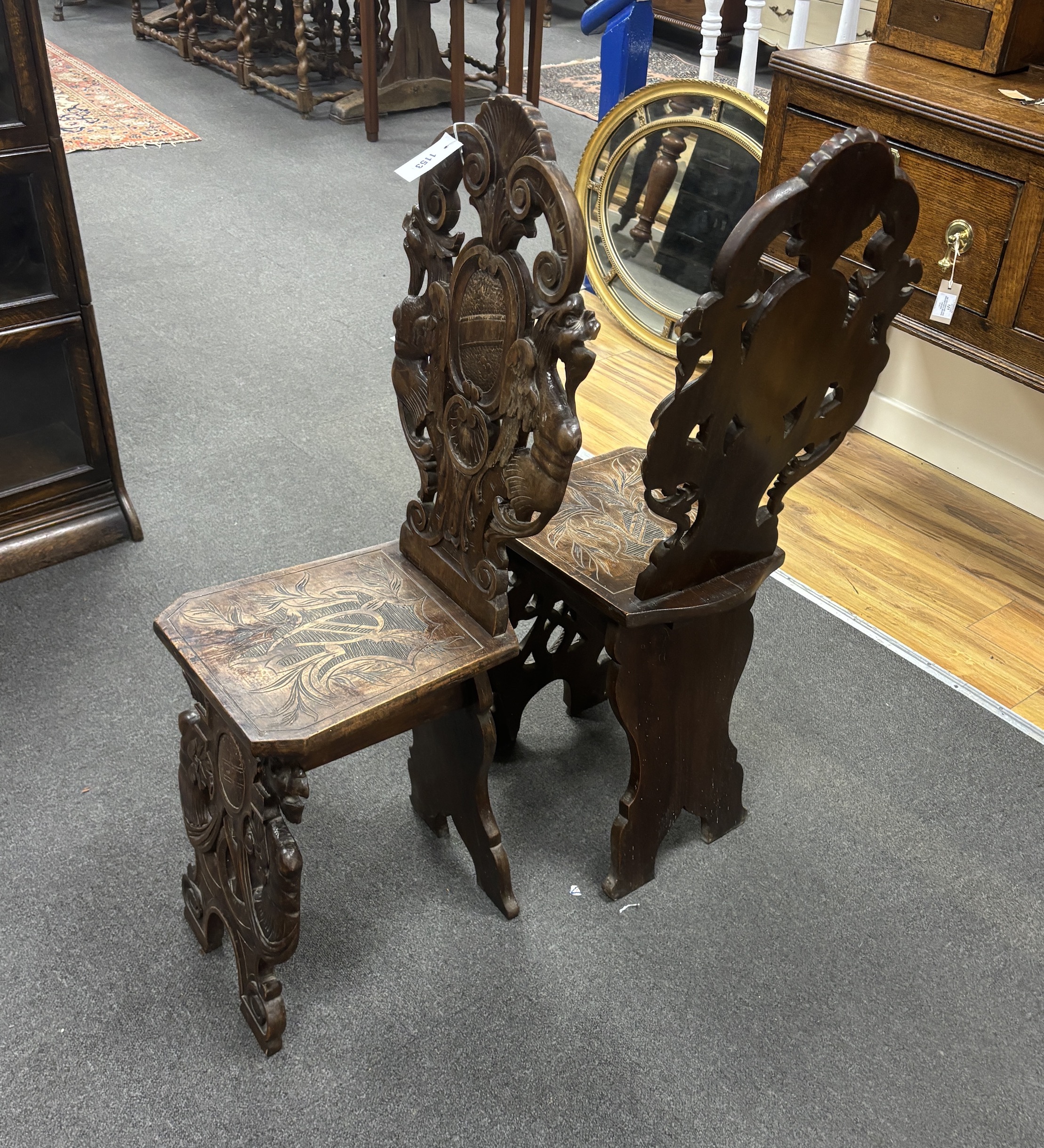 A pair of 18th century style carved walnut hall chairs, width 36cm, depth 27cm, height 106cm